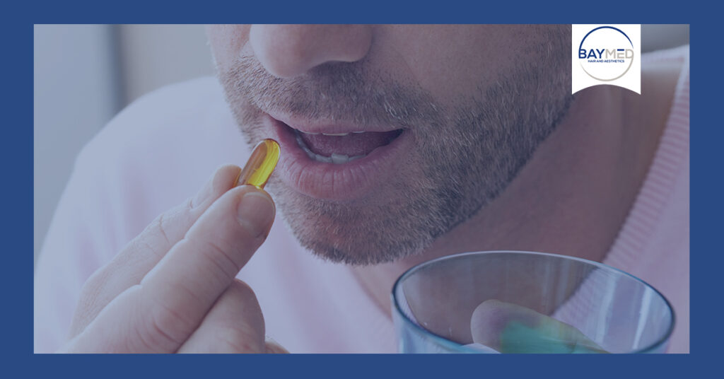 Man taking supplements with water.