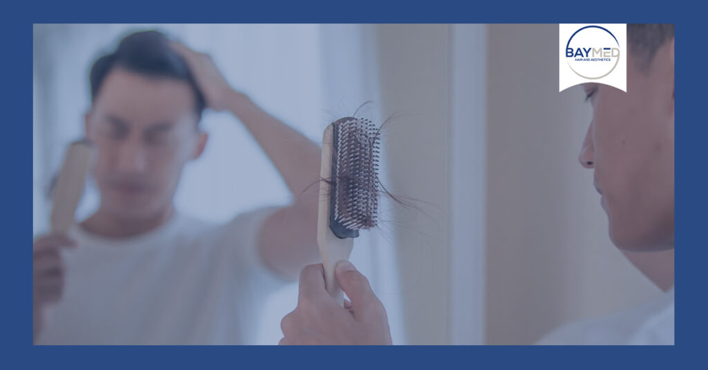 Man staring at hair stuck in brush