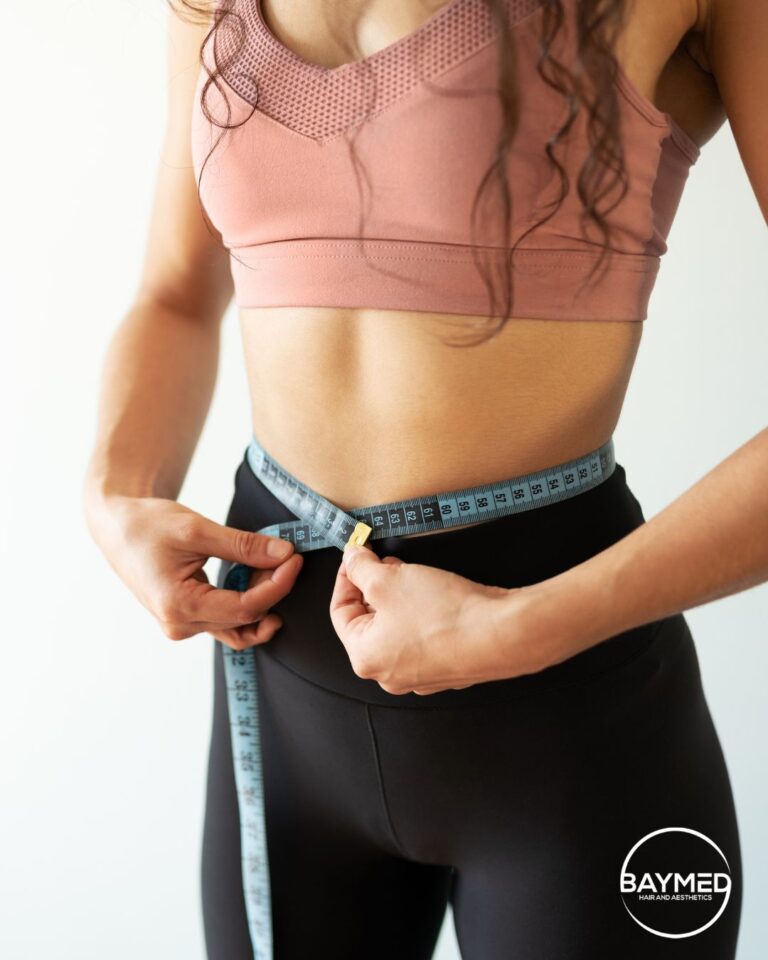 Woman measuring her waist during a medical weight loss program