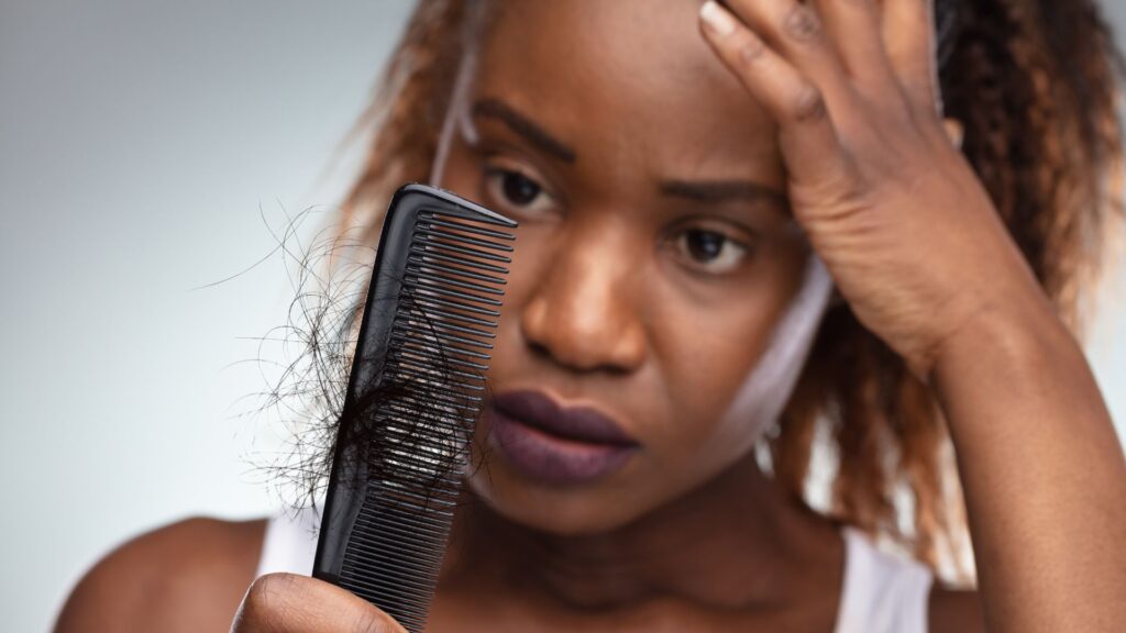 Woman checking hair loss on her comb, hair loss treatment for women in St. Petersburg